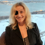 Jacinthe Potvin, souriante, devant une fenêtre donnant sur un plan d'eau